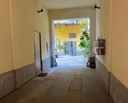Entra e cammina fino in fondo all’androne.